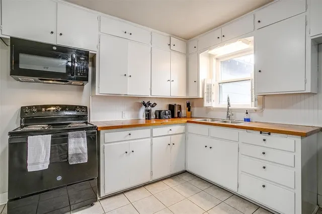 a kitchen with granite countertop white cabinets stainless steel appliances and a window
