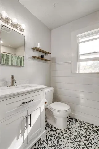 a bathroom with a sink a toilet and a mirror