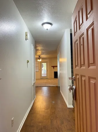 a view of hallway with stairs and wooden floor