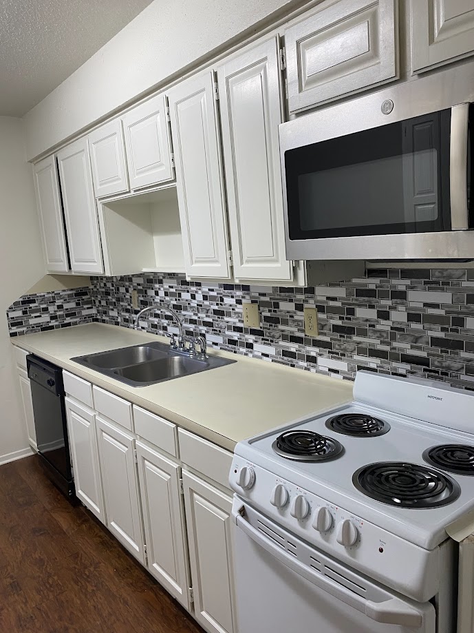 1305 West Villa Maria Road, Unit C103 Bryan, TX 77801 - Photo 7 of 19 a kitchen with a stove and a microwave