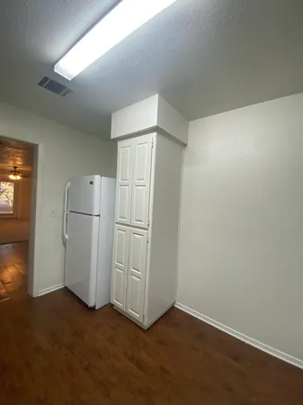 a view of empty room with wooden floor and cabinets