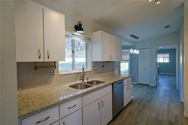 a kitchen with sink cabinets and wooden floor