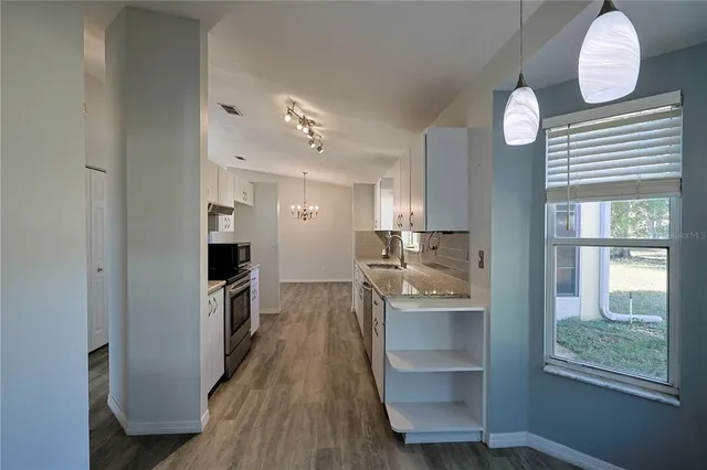 a kitchen with kitchen island a counter space a sink and appliances