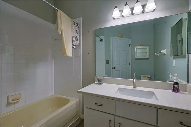 a bathroom with a sink a tub and a mirror