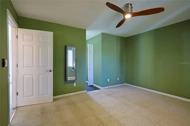 an empty room with closet and a chandelier fan