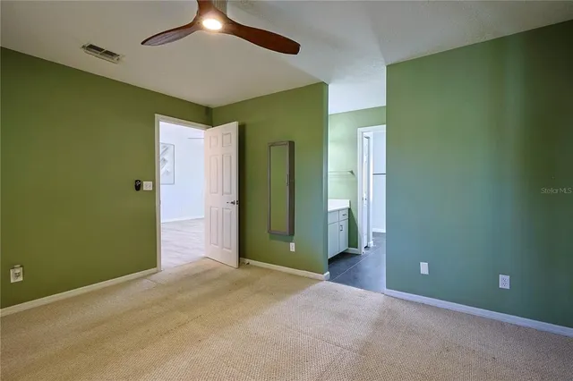 an empty room with closet and fan