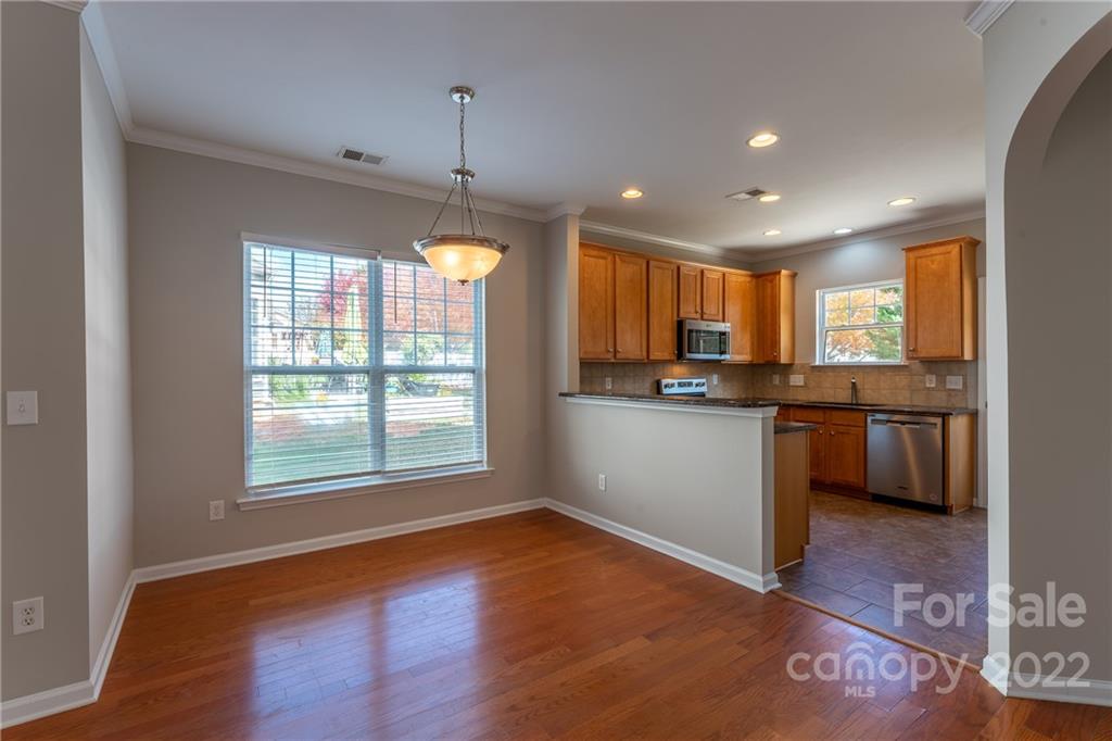 261 Sand Paver Way Fort Mill, SC 29708 - Photo 23 of 45 a kitchen with granite countertop wooden floors stainless steel appliances and sink