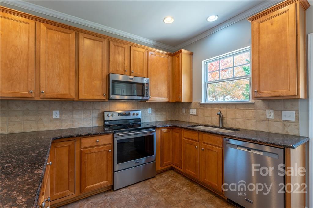 261 Sand Paver Way Fort Mill, SC 29708 - Photo 10 of 45 a kitchen with stainless steel appliances granite countertop wooden cabinets a sink and a window