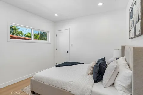 a bedroom with a large bed and a potted plant