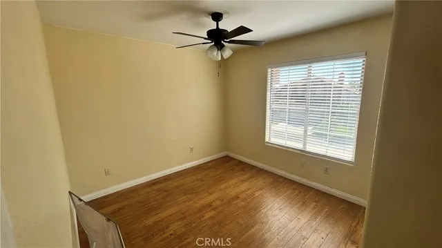 a view of a room with a window and a ceiling fan