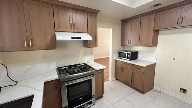 a kitchen with wooden cabinets and a stove top oven