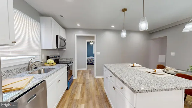 a kitchen with a sink stove and wooden floor