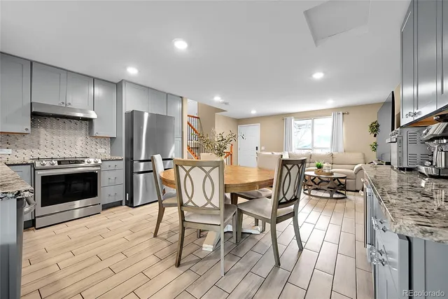 a kitchen with stainless steel appliances kitchen island granite countertop a stove a sink a refrigerator and cabinets