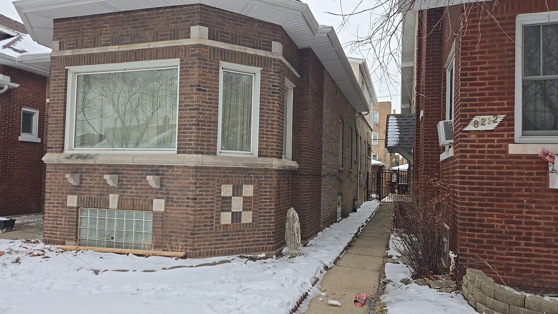 8216 South Rhodes Avenue Chicago, IL 60619 - Photo 2 of 22 a view of a brick house with wooden fence