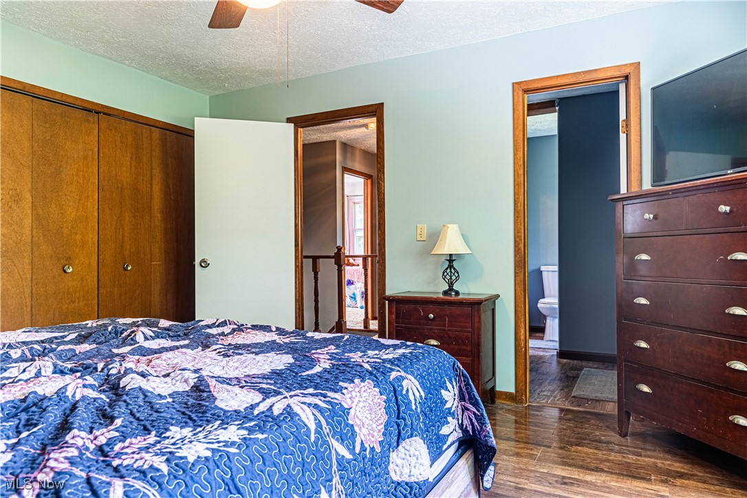 16974 Hawley Road Oberlin, OH 44074 - Photo 17 of 42 Bedroom with a textured ceiling, dark wood-type flooring, a ceiling fan, and a closet