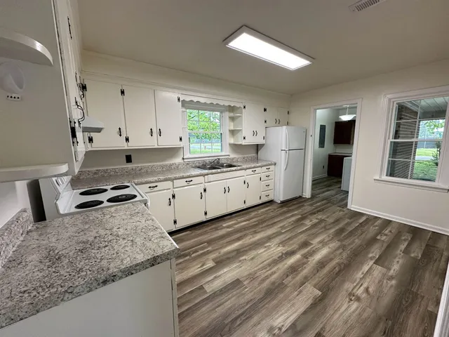 a kitchen with granite countertop a sink a stove and cabinets