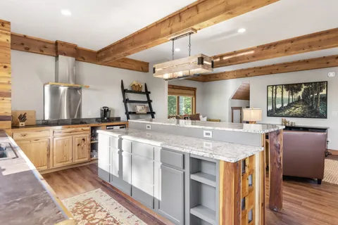 a view of a white house next to a yard with a tree