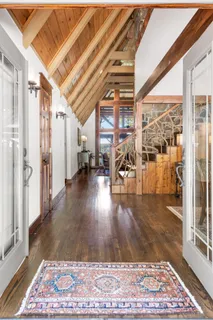 a living room with furniture and a floor to ceiling window next to a yard