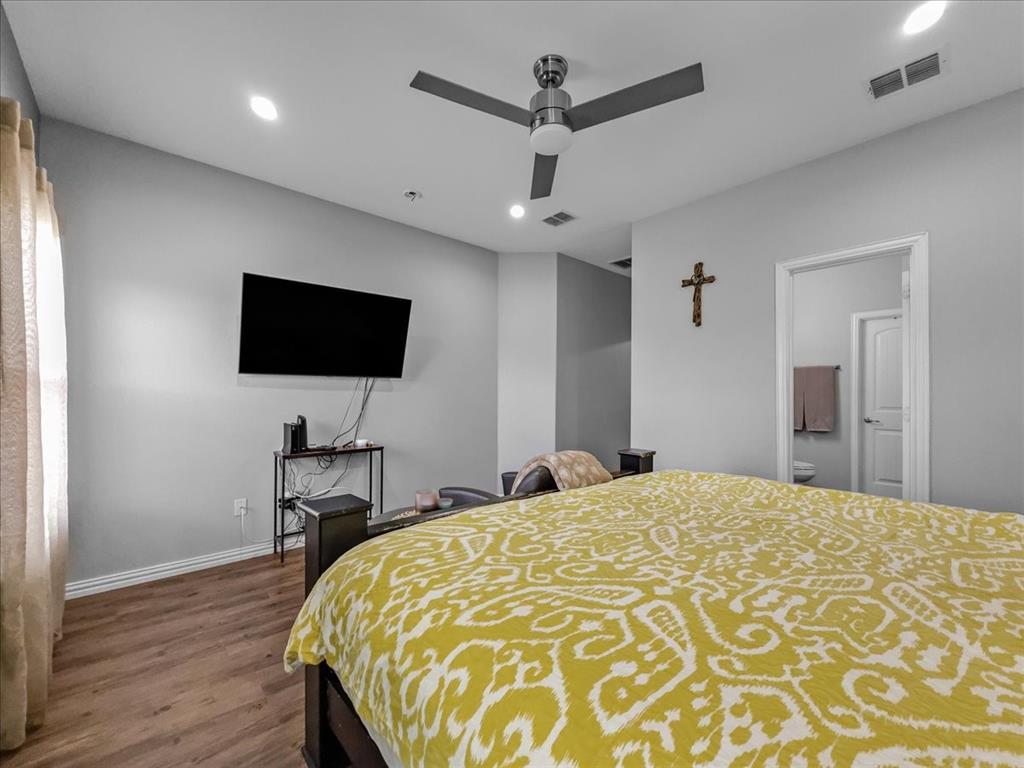 14201 Bridgeview Lane Dallas, TX 75253 - Photo 16 of 26 a bedroom with a bed and a flat screen tv