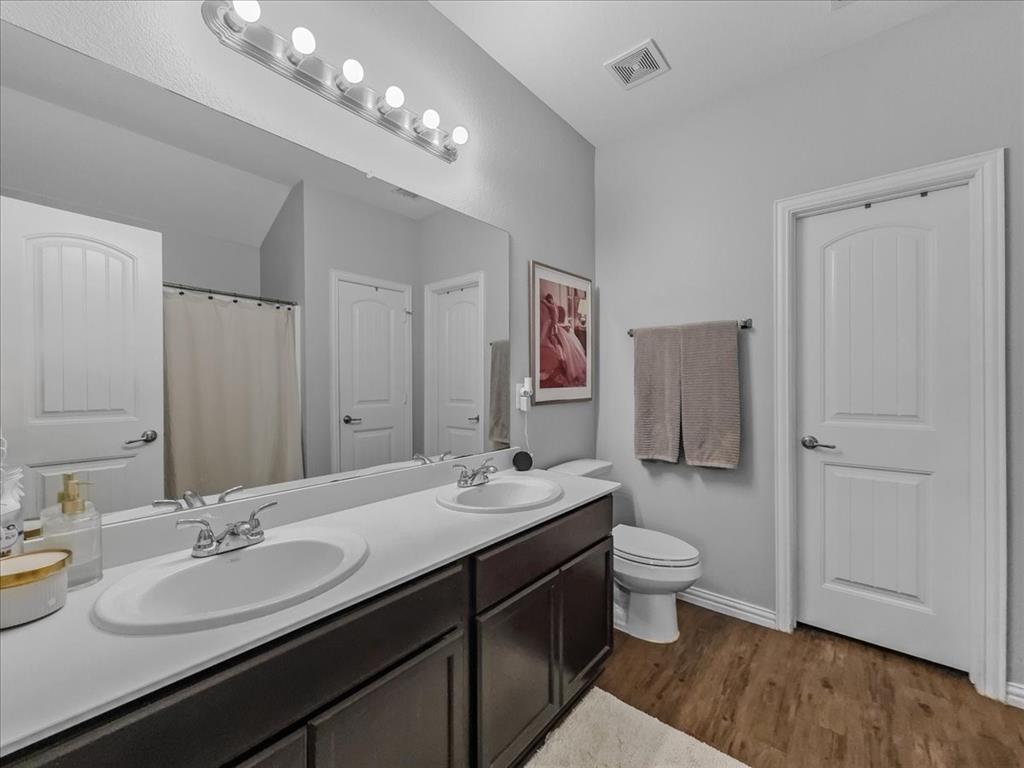 14201 Bridgeview Lane Dallas, TX 75253 - Photo 18 of 26 a bathroom with a double vanity sink mirror and toilet