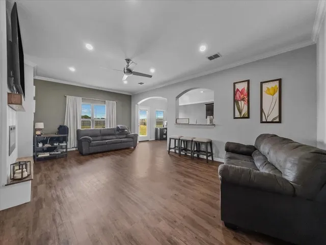 a living room with furniture and a wooden floor