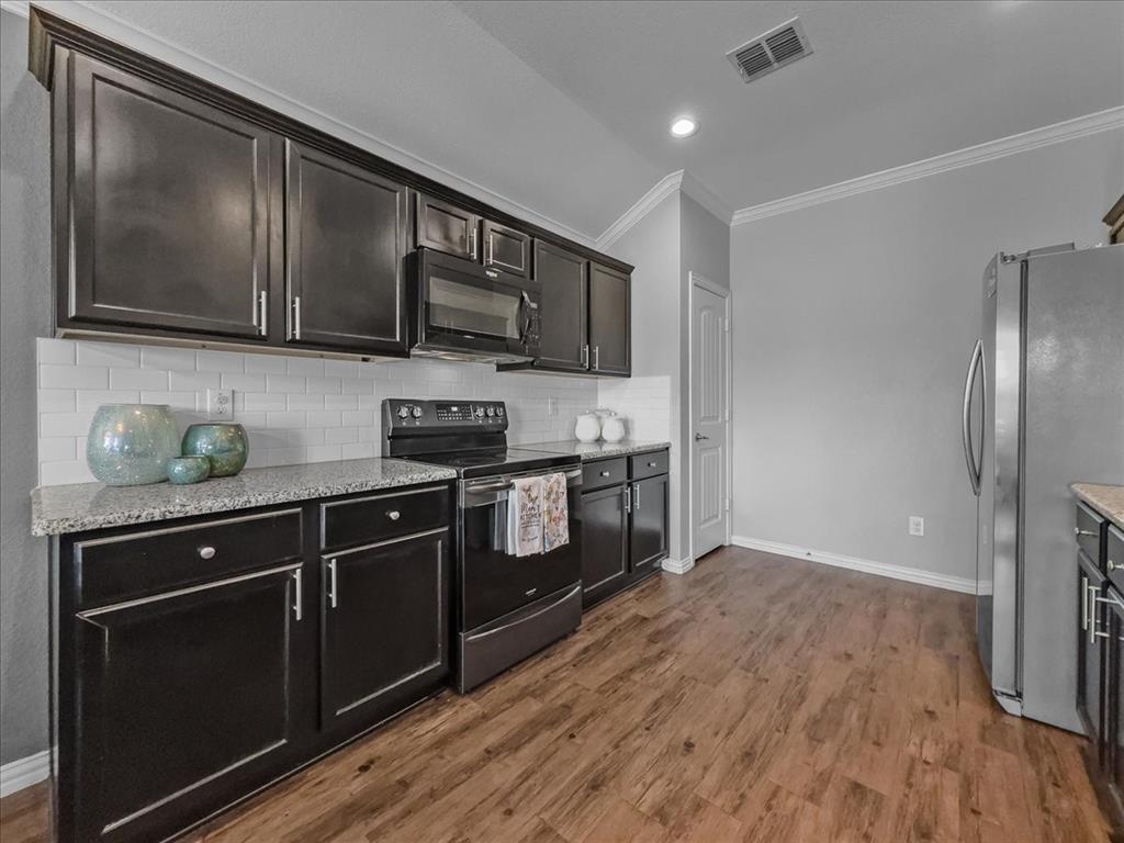 14201 Bridgeview Lane Dallas, TX 75253 - Photo 6 of 26 a kitchen with stainless steel appliances granite countertop a stove a sink and a microwave