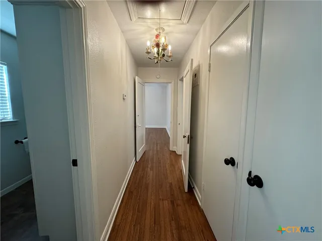 a view of a hallway with wooden floor and stairs