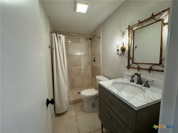 a bathroom with a granite countertop sink toilet and shower