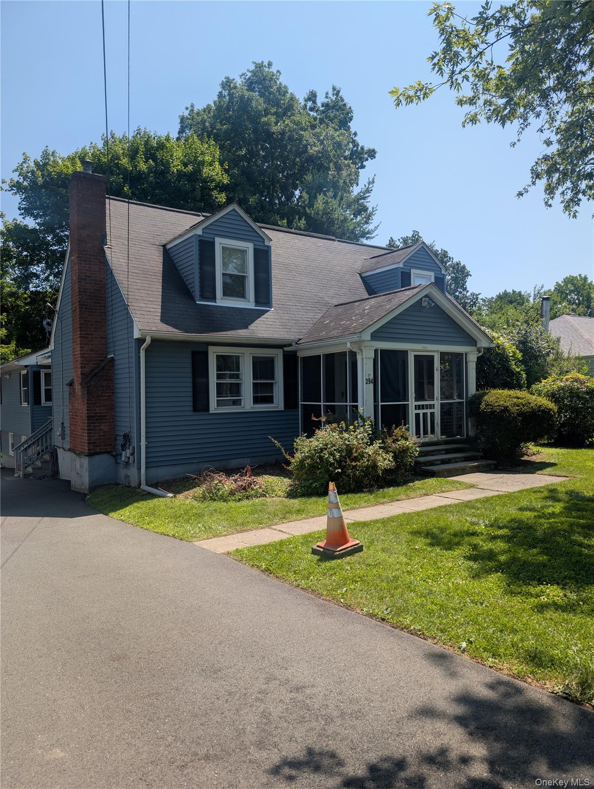 394 Riley Road, Unit 1 New Windsor, NY 12553 - Photo 3 of 24 Dormered Cape Cod features blue siding, a screened-in porch, a brick chimney, and a paved driveway