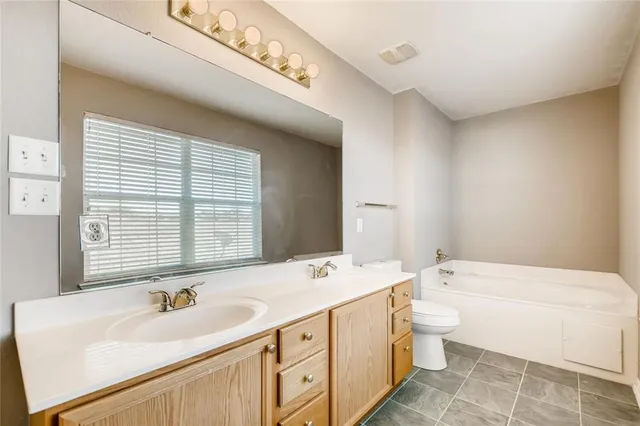 a spacious bathroom with a double vanity sink a mirror and a bathtub