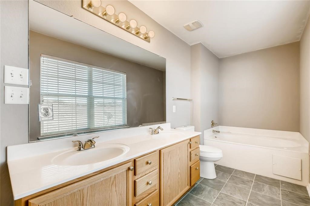 1149 Apollo Circle Round Rock, TX 78664 - Photo 11 of 14 a spacious bathroom with a double vanity sink a mirror and a bathtub