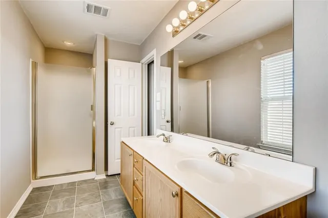 a bathroom with a double vanity sink and a mirror