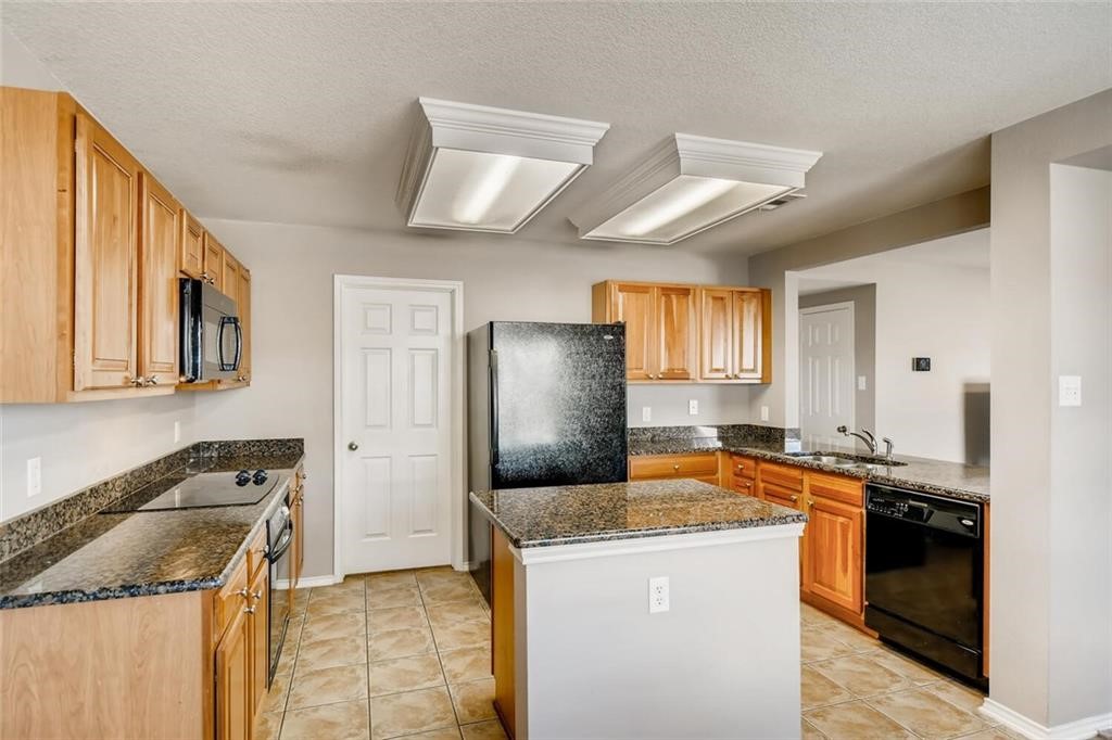 1149 Apollo Circle Round Rock, TX 78664 - Photo 6 of 14 a kitchen with granite countertop a sink a stove and refrigerator