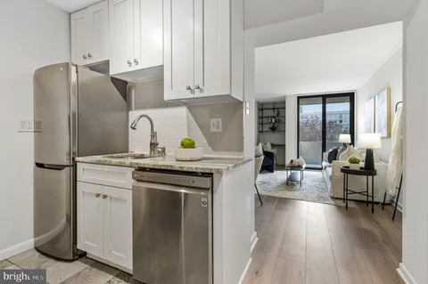 a kitchen with stainless steel appliances granite countertop a refrigerator a stove and a wooden floors