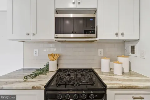 a stove top oven sitting inside of a kitchen