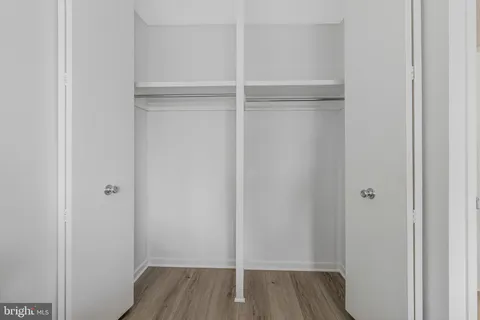 a view of walk in closet with wooden floor