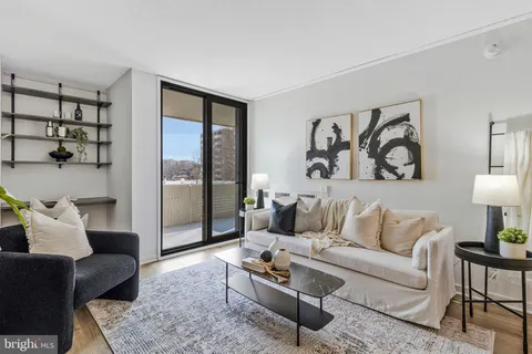 a living room with furniture and a painting on the wall
