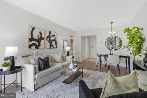 a living room with furniture a rug and a wall clock
