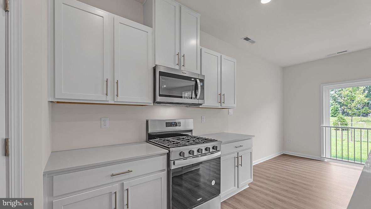 155 Littleworth Road Manahawkin, NJ 08050 - Photo 9 of 32 a kitchen with white cabinets and appliances