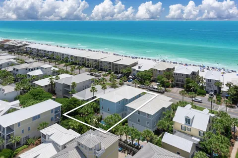 an aerial view of residential houses with outdoor space and ocean view