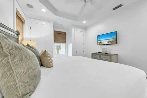 a spacious bedroom with a large bed and a chandelier