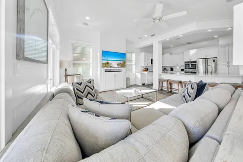 a living room with furniture kitchen view and a chandelier