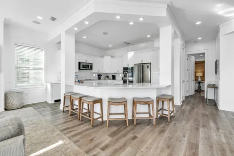 a kitchen with stainless steel appliances kitchen island granite countertop a refrigerator and microwave