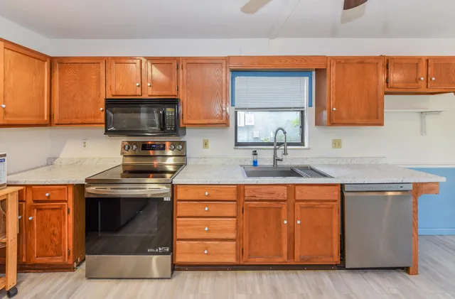 a kitchen with stainless steel appliances a stove sink and microwave