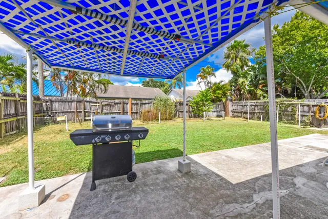 a view of a patio with table and chairs potted plants and palm trees