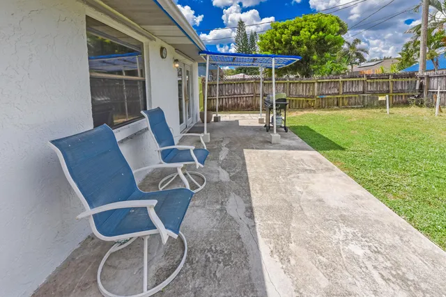 a sign that is sitting in the grass near a tree