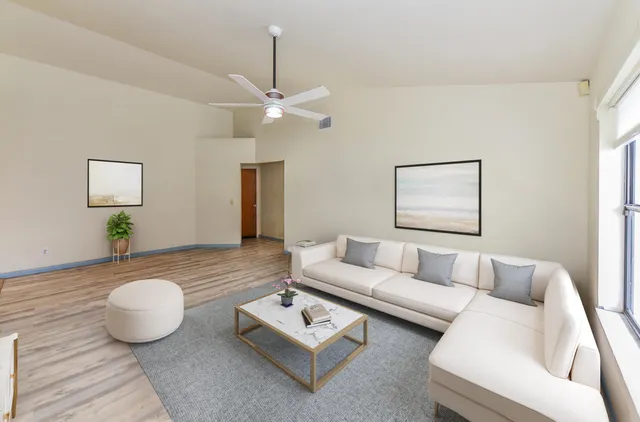 a living room with furniture and a wooden floor