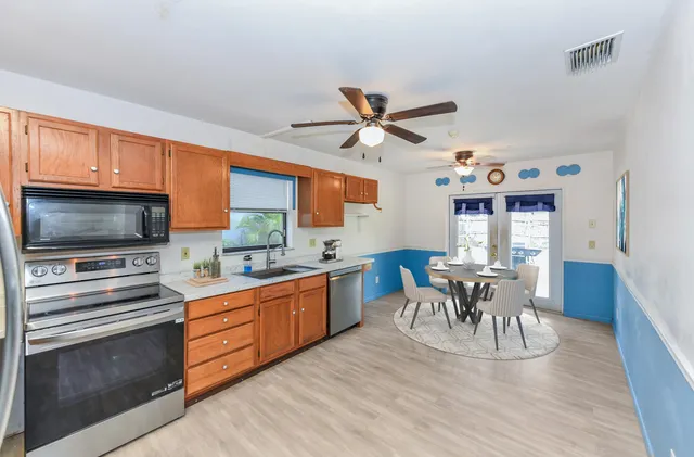 a kitchen with granite countertop a sink appliances and dining table