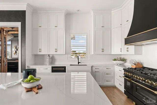 a utility room with stainless steel appliances granite countertop a sink and a window