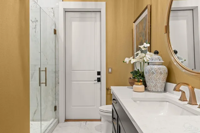 a bathroom with a shower sink vanity mirror and toilet